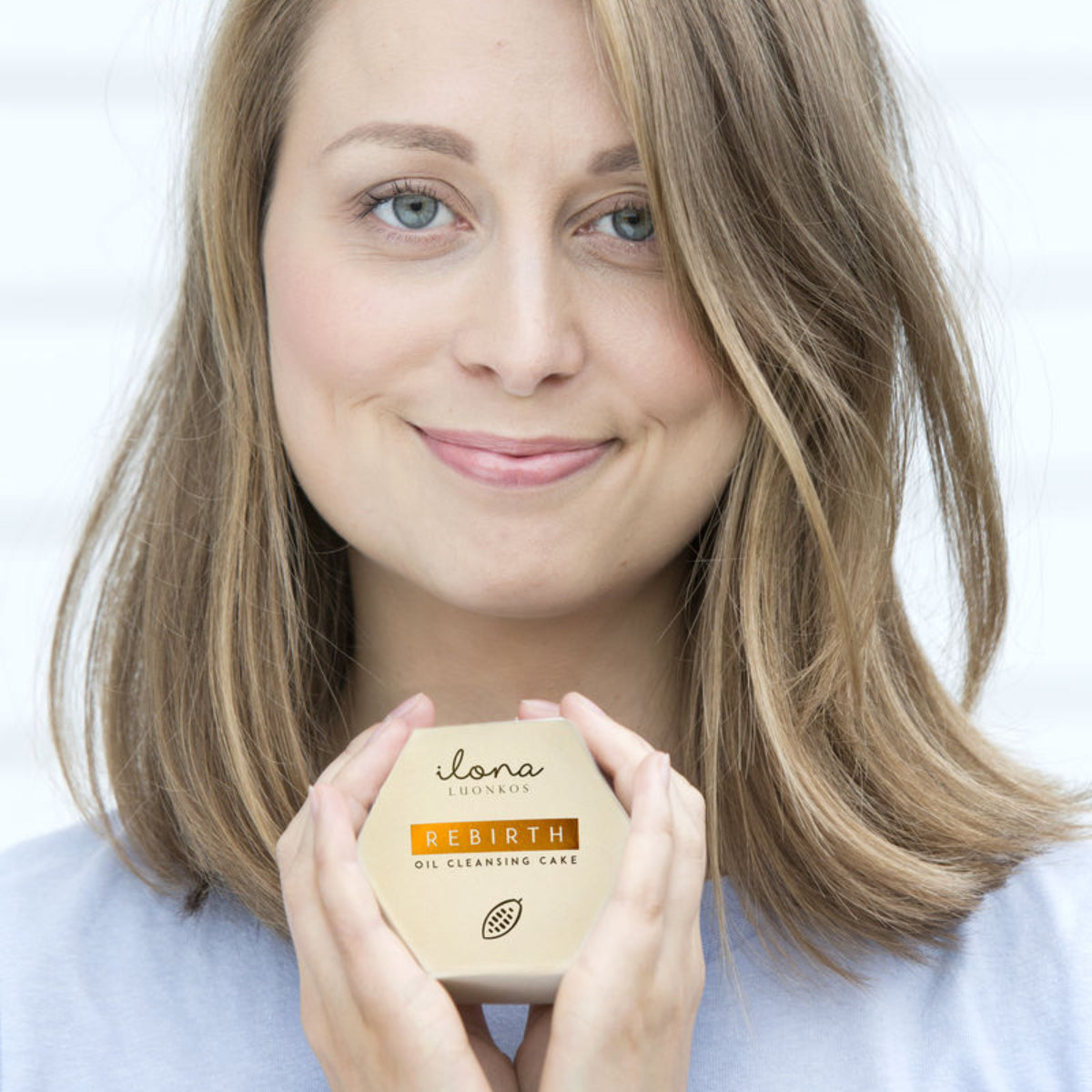 Woman holding Ilana Luskyko Oil Cleansing Cake Rebirth for radiance and moisture balance.